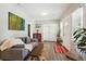 Bright living room featuring grey sofa, decorative art, and a glimpse of the front door at 1456 Syracuse St, Denver, CO 80220