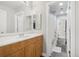 Bathroom with wood vanity, white countertop, framed mirror, toilet, tiled floors, and shower at 6553 S Sedalia St, Aurora, CO 80016