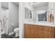 Neutral bathroom featuring a wood vanity, white countertop, framed mirror, toilet and tiled floors at 6553 S Sedalia St, Aurora, CO 80016