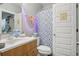 Full bathroom with a modern vanity, toilet, and shower with stylish patterned curtain at 6553 S Sedalia St, Aurora, CO 80016