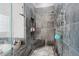 Elegant walk-in shower featuring stone tile and built in seat and shelving at 6553 S Sedalia St, Aurora, CO 80016