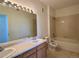 Bright bathroom with double sink vanity, large mirror, and shower-tub combination at 8481 W Union Ave # 2-204, Littleton, CO 80123