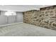 Finished basement featuring a unique stone wall and neutral carpet at 5725 W Mississippi Ave, Lakewood, CO 80226
