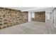 Basement area showcasing a striking stone wall and access to multiple rooms at 5725 W Mississippi Ave, Lakewood, CO 80226