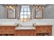 Bathroom featuring double sinks, wood cabinets, and matching framed mirrors at 5725 W Mississippi Ave, Lakewood, CO 80226
