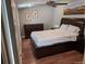 Well-lit bedroom with hardwood floors, dresser, and a comfortable bed with storage drawers at 5725 W Mississippi Ave, Lakewood, CO 80226