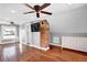 Bedroom featuring hardwood floors, a brick accent wall, ceiling fan, and a TV at 5725 W Mississippi Ave, Lakewood, CO 80226