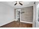 Bedroom with hardwood floors, an accent wall, a ceiling fan, and a large window at 5725 W Mississippi Ave, Lakewood, CO 80226