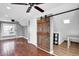 Bedroom with hardwood floors, ceiling fans, and a rustic barn door at 5725 W Mississippi Ave, Lakewood, CO 80226