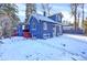 Charming blue home with red-painted porch steps, snow-covered yard, and mature trees at 5725 W Mississippi Ave, Lakewood, CO 80226