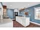 Bright kitchen features a stainless steel fridge, white cabinets, a kitchen island, and lots of light at 5725 W Mississippi Ave, Lakewood, CO 80226