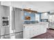 Bright kitchen features a stainless steel fridge, white cabinets, and a kitchen island at 5725 W Mississippi Ave, Lakewood, CO 80226