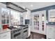 Updated kitchen with stainless steel range, oven, and hood with large windows overlooking the yard at 5725 W Mississippi Ave, Lakewood, CO 80226
