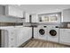 Bright laundry room with white cabinets, a sink, and modern washer and dryer at 5725 W Mississippi Ave, Lakewood, CO 80226