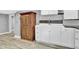 Laundry area featuring white cabinets, a utility sink, and wood accents at 5725 W Mississippi Ave, Lakewood, CO 80226