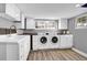 Bright laundry room with white cabinets, sink, and modern washer and dryer at 5725 W Mississippi Ave, Lakewood, CO 80226