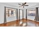 Living room featuring hardwood floors, large windows, and a ceiling fan for optimal lighting at 5725 W Mississippi Ave, Lakewood, CO 80226