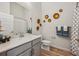 Well-lit bathroom featuring modern decor, single vanity sink, and tiled shower with modern art at 487 Interlocken Blvd # 104, Broomfield, CO 80021
