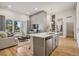 Spacious living area featuring kitchen island, comfortable sofa, and a door to a balcony at 487 Interlocken Blvd # 104, Broomfield, CO 80021