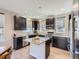 Stylish kitchen featuring dark cabinets, granite countertops, stainless steel appliances, and a functional island at 10071 Belvedere Cir, Lone Tree, CO 80124