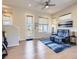 Bright living room with modern ceiling fan, lots of natural light, and stylish blue rug at 10071 Belvedere Cir, Lone Tree, CO 80124