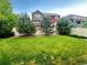 Well-maintained backyard with lush green grass, privacy fence, and mature trees at 133 Poppy View Ln, Erie, CO 80516