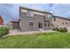 Home's backyard featuring a lush lawn and patio, with a sliding door entrance at 133 Poppy View Ln, Erie, CO 80516