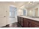 Bathroom featuring double sinks, granite countertops, tile floors, and an open view to a bonus room at 133 Poppy View Ln, Erie, CO 80516