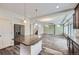 Open-concept layout showcases kitchen island with granite counters and stainless steel refrigerator at 133 Poppy View Ln, Erie, CO 80516