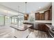 Open kitchen features a central island, granite countertops, and wood cabinets for a modern design at 133 Poppy View Ln, Erie, CO 80516