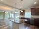 Spacious kitchen island with hanging lights, stainless steel appliances, and hardwood floors at 133 Poppy View Ln, Erie, CO 80516