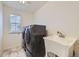 Bright laundry room featuring modern washer and dryer, tiled floors, and a utility sink at 133 Poppy View Ln, Erie, CO 80516