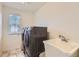 Well-lit laundry room with modern washer and dryer appliances and utility sink at 133 Poppy View Ln, Erie, CO 80516