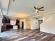 Bright open-concept living room and kitchen with hardwood floors and modern ceiling fan at 133 Poppy View Ln, Erie, CO 80516