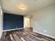 Living room with accent wall, hardwood floors and doorway to adjacent room at 133 Poppy View Ln, Erie, CO 80516