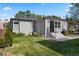 Grassy backyard featuring a covered grill, landscaping, and a modern-style brick home at 785 Dexter St, Denver, CO 80220