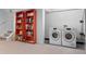 Basement featuring orange bookshelves, a laundry area, and access to the stairs at 785 Dexter St, Denver, CO 80220