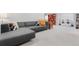 Basement featuring a gray sectional sofa, orange bookshelves, and a laundry area at 785 Dexter St, Denver, CO 80220