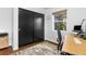 Bright bedroom featuring modern closet doors, a wooden desk, and a patterned rug at 785 Dexter St, Denver, CO 80220