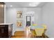 Dining area with yellow chairs and wood floors, adjacent to kitchen at 785 Dexter St, Denver, CO 80220