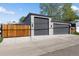 View of the three-car garage, with a wooden fence in the foreground at 785 Dexter St, Denver, CO 80220