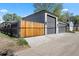 View of the three-car garage, with a wooden fence in the foreground at 785 Dexter St, Denver, CO 80220
