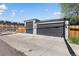 View of the three-car garage with lights and a driveway at 785 Dexter St, Denver, CO 80220