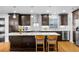 Elegant kitchen featuring dark cabinets, stainless steel appliances, and a center island at 785 Dexter St, Denver, CO 80220