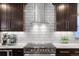 Modern kitchen with stainless steel appliances, white backsplash, and dark cabinets at 785 Dexter St, Denver, CO 80220
