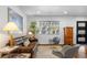 Cozy living room featuring a leather sofa, modern chairs, and hardwood floors at 785 Dexter St, Denver, CO 80220