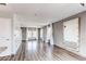 Spacious living room with wood floors, gray walls, and ample natural light from the three windows at 3607 Dinosaur St, Castle Rock, CO 80109