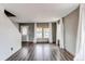 Open living room with wood floors, large windows, and a white door with glass at 3607 Dinosaur St, Castle Rock, CO 80109