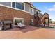 An expansive backyard with a patio, grill, and stone-and-siding house exterior at 7410 S Old Hammer Way, Aurora, CO 80016