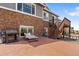 An expansive backyard with a patio, grill, and stone-and-siding house exterior at 7410 S Old Hammer Way, Aurora, CO 80016